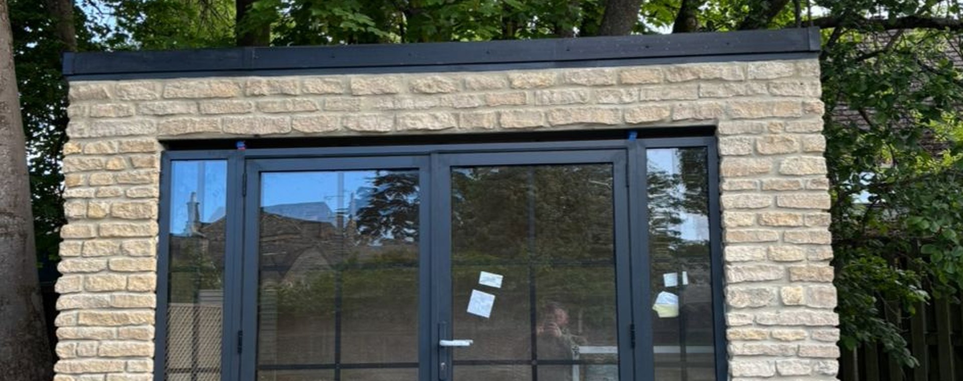Garden garage with glazed blue-framed doors