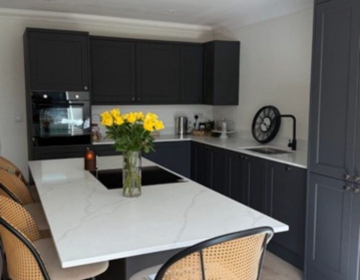 Modern fitted kitchen with dark cabinetry and island seating