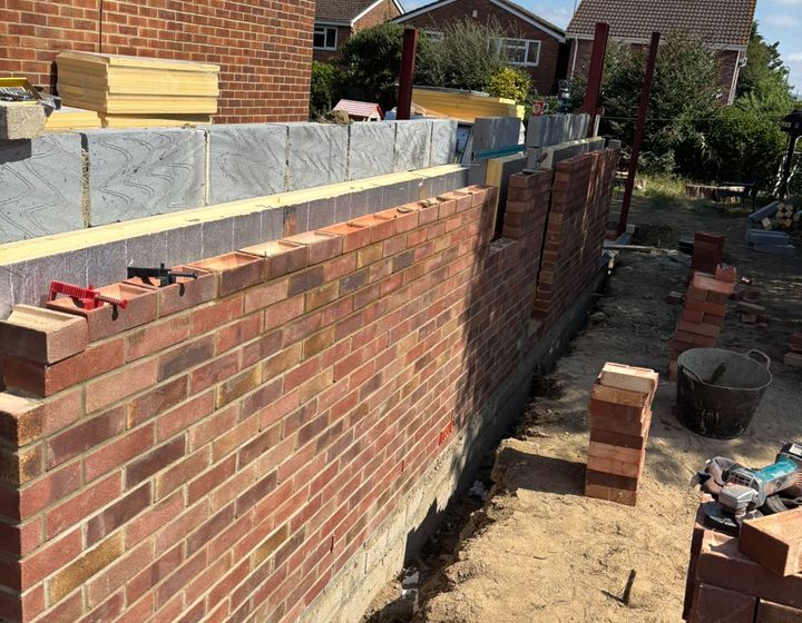 Red-brick cavity wall construction with insulation and steel columns